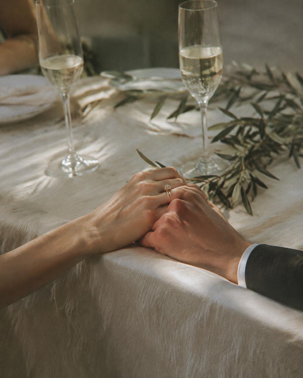 Mãos do casal sobre a mesa